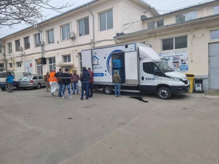 Demonstrație tehnică în fața autoutilitarei, cu participanți pe șantier