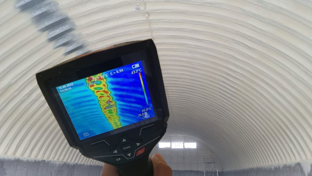 Termografie pe bolta unei hale izolate cu spumă poliuretanică: 26 °C pe suprafața izolată și 43,2 °C pe îmbinarea de la coamă