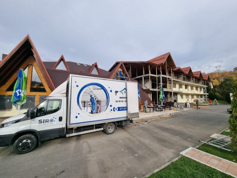 Autoutilitara echipei pe șantierul unui complex din lemn, pregătită pentru izolarea pereților